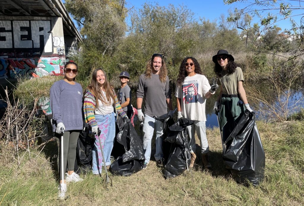 Clean And Green volunteers A group of volunteers stand in front of the River during a clean up event.