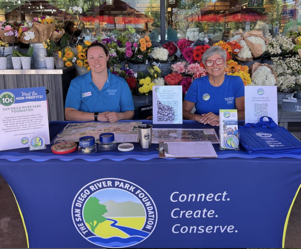Community Engagement Volunteers Two volunteers for the San Diego River Park Foundation sit at a booth ready to share information about the organization.