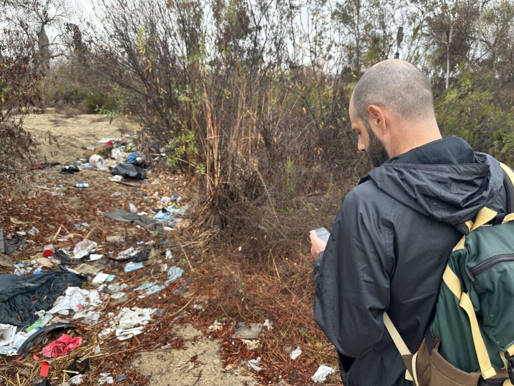 RAFT documenting trash A RAFT team member documents trash along the riverbed.