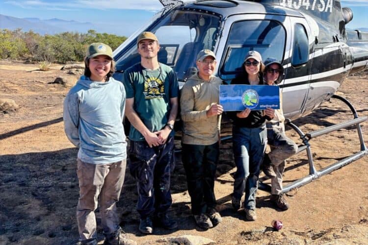 SDRPF staff and volunteers in front of helicopter that took them to the top of El caiptan Preserve to survey after the fire.