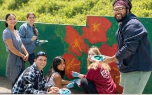 group of college ages kids painting a mural