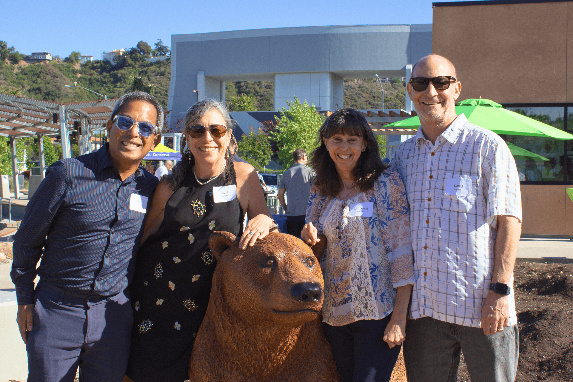 4 people standing by bear statue at Grant Park smiling