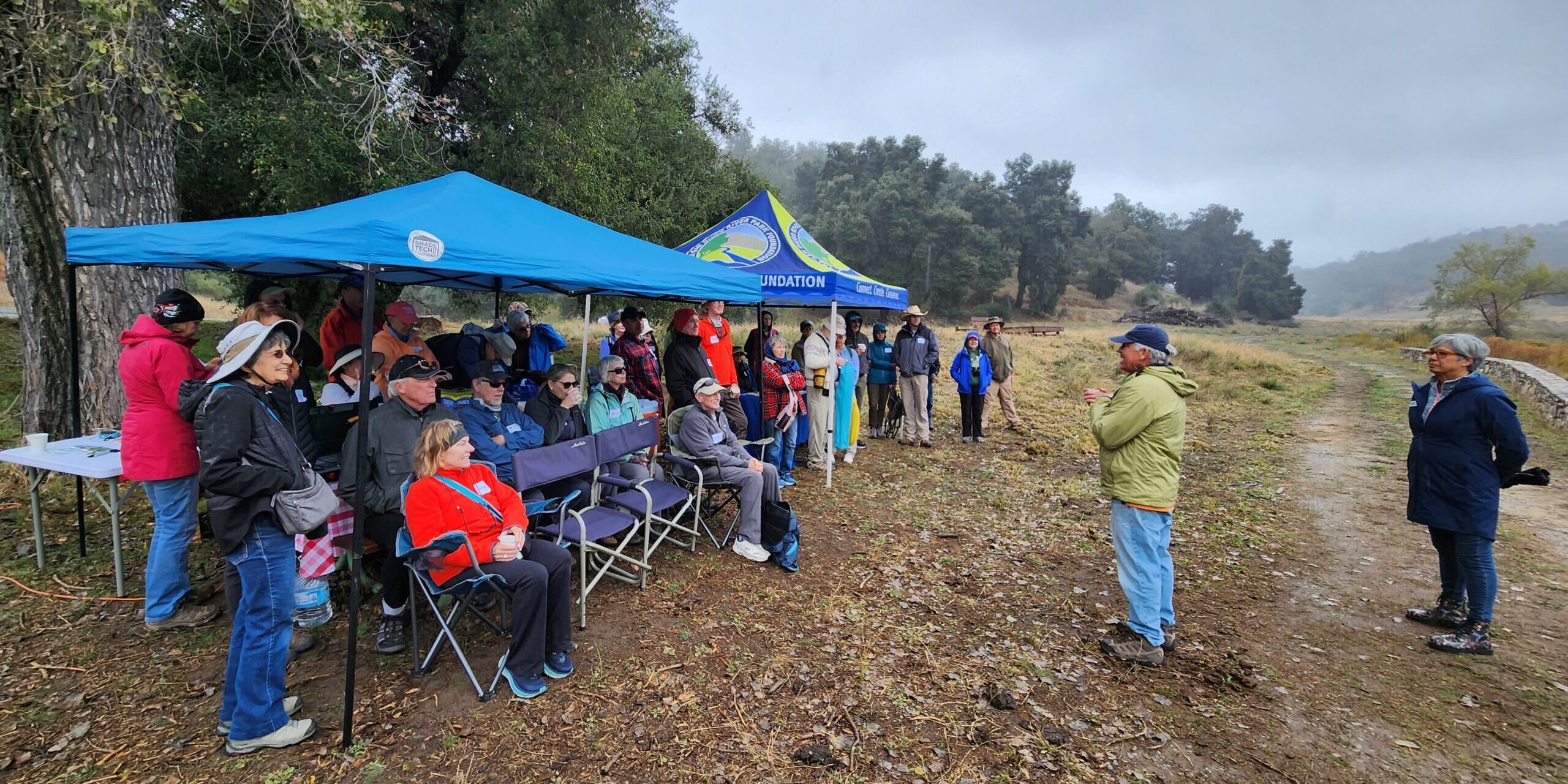 A group of hikers meet with hike leaders before heading out on the trail.