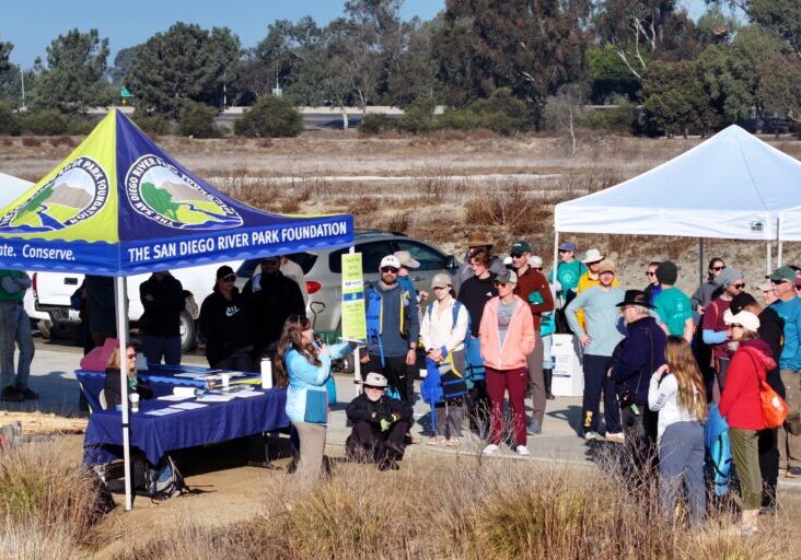 A group of San Diego River Park Foundation volunteers gathers to receive information and instructions.
