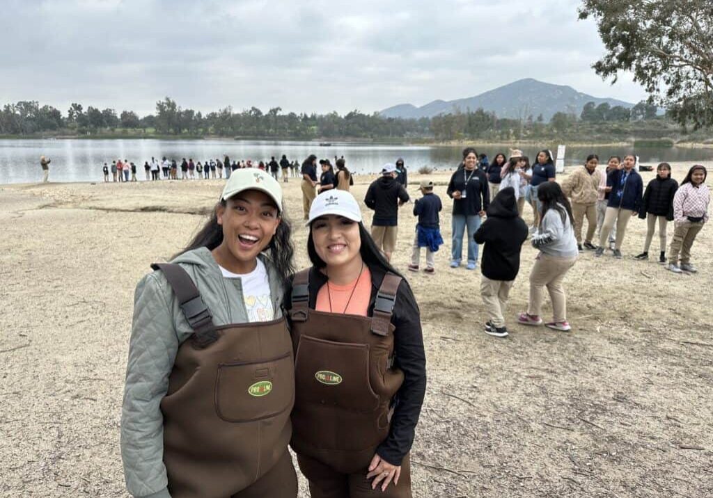 WATER TR Teachers In Waders 1 LM 2024 SF Teachers in waders pose for a picture during a trout release at Lake Murray